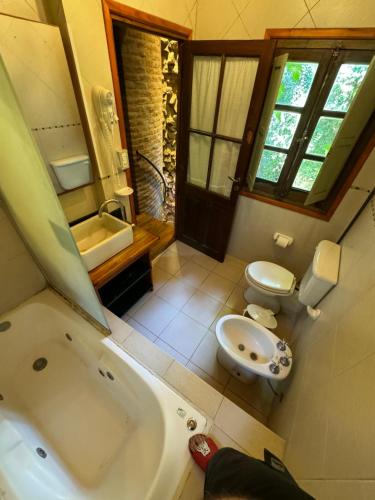 La salle de bains est pourvue d'une baignoire, d'un lavabo et de toilettes. dans l'établissement Cabañas Arehue, à Mar del Plata