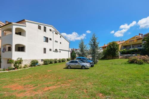 a car parked in a yard next to a building at Apartments Dragica in Štinjan