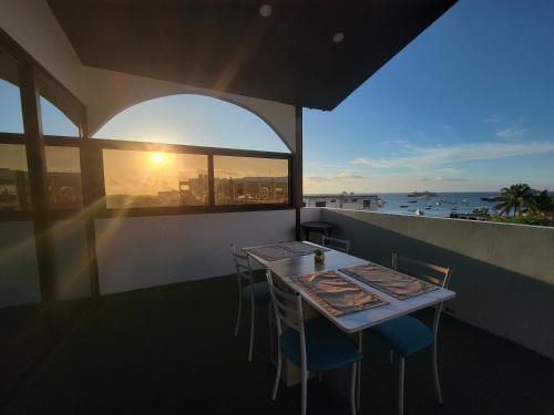 a table on a balcony with a view of the ocean at Hostal Gosén in Puerto Baquerizo Moreno
