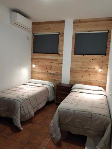 2 camas en una habitación con 2 monitores en la pared en Alojamiento Mercado de Abastos, en Úbeda