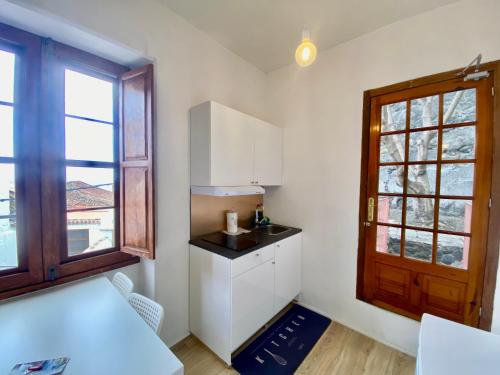 una cocina con armarios blancos y una ventana en Secret Spot Santa Cruz, en Santa Cruz de la Palma