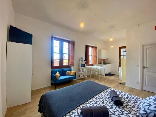 1 dormitorio con 1 cama y 1 sofá azul en Secret Spot Santa Cruz, en Santa Cruz de la Palma