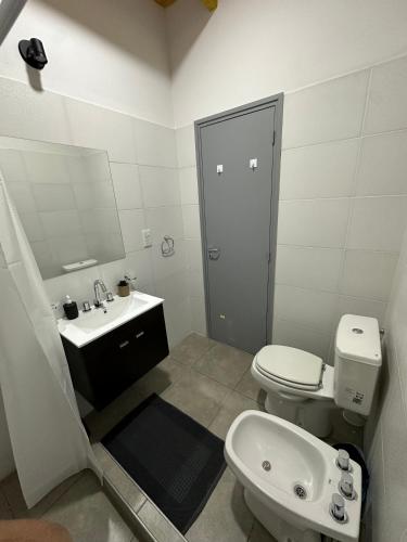 a white bathroom with a toilet and a sink at Increíble departamento a estrenar en Mendoza in Godoy Cruz