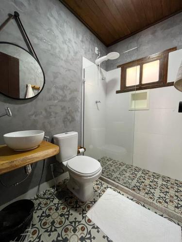 a bathroom with a toilet and a sink and a shower at Pousada Veleiro Itaúnas in Itaúnas