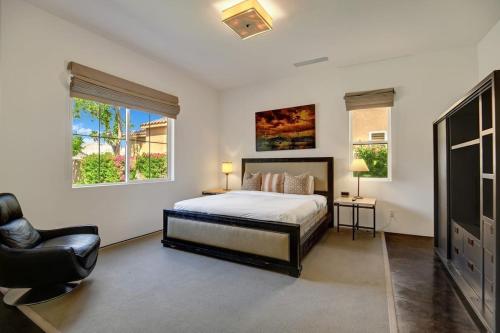 - une chambre avec un lit, une chaise et deux fenêtres dans l'établissement Legends by AvantStay Stunning Golf Villa Featuring Spa Pool Fire-Pit, à La Quinta