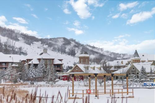 a lodge in the snow with a mountain in the background at Blue Mtn Getaway in Historic Snowbridge Chalet in Collingwood
