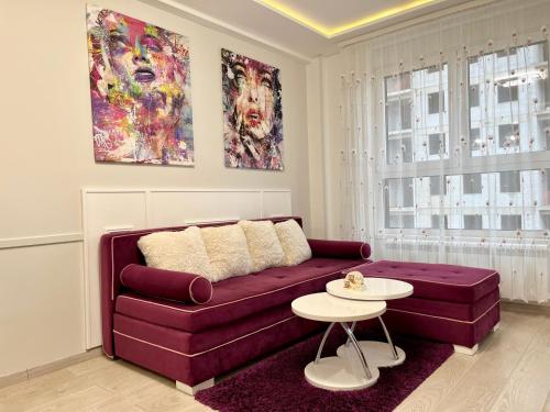 a living room with a purple couch and a table at Apartmani SLEEP&JOY in Zlatibor