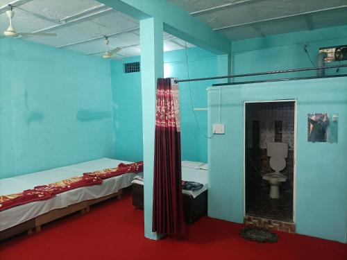 Shri Gamya Guest House في اوجاين: غرفة بسريرين وحمام مع مرحاض