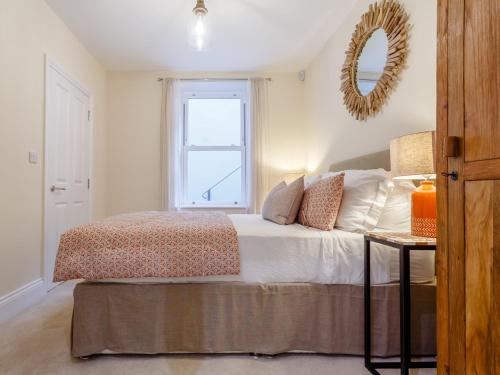 1 dormitorio con 1 cama con ventana y espejo en 2 Bed in Westward Ho 77590, en Northam