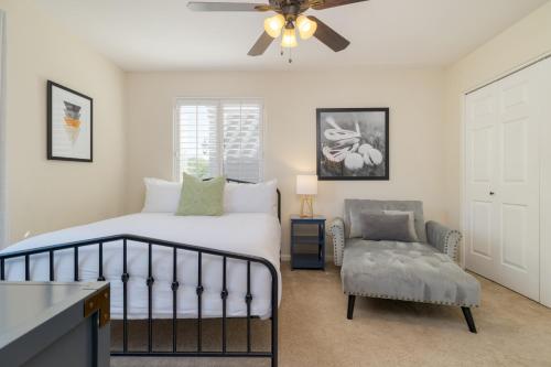 a bedroom with a bed and a chair and a ceiling fan at Sonoran Sunshine by AvantStay Pool Putting Green BBQ Ping Pong Pool Table Entertainers Wonderland in Scottsdale