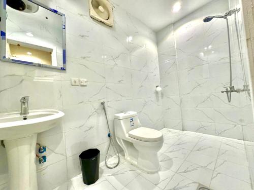 a white bathroom with a toilet and a sink at Boho lovely - بتسجيل وصول ذاتي in Riyadh