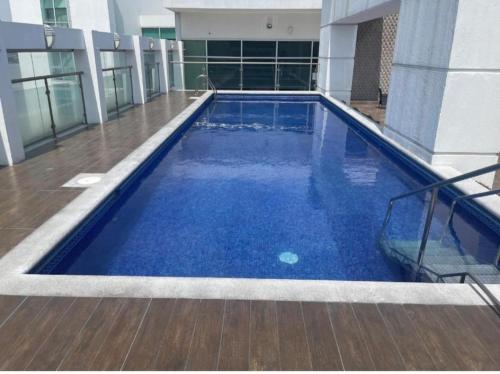 una gran piscina azul en un edificio en Suite Riverfront, en Guayaquil