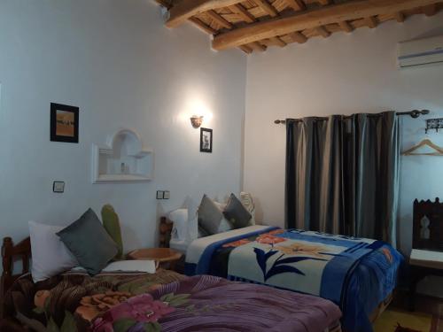 Imdiazene的住宿－HôteL Berbère de la Montagne，一间卧室设有两张床、一张沙发和一个窗口