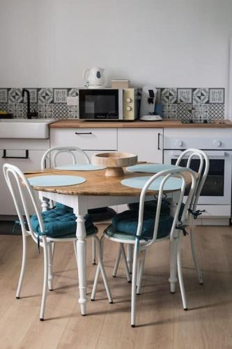une cuisine avec une table et des chaises dans une cuisine dans l'établissement Maupiti proche Etretat et Fécamp, à Vattetot-sur-Mer