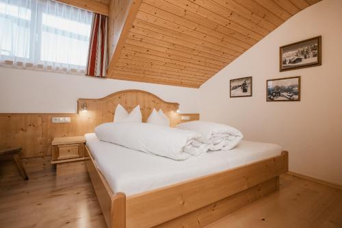 a bedroom with a large bed with a wooden headboard at Apart Tyrol in Serfaus