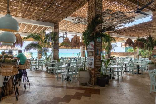 un restaurante con mesas y sillas y el océano en La Palma Beachfront Hotel Boutique - Self Check In en Cancún