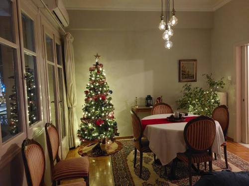 a christmas tree in a dining room with a table at Apartment overlooking the old bridge in Chalkida