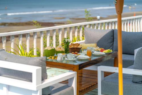 a tray of food on a table on a balcony with the beach at La Cabana Beach & Spa, By Ashvem Beach in Mandrem