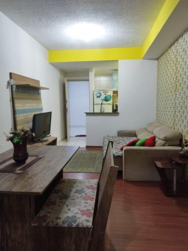 a living room with a couch and a table at Apartamento Praia do Morro in Guarapari