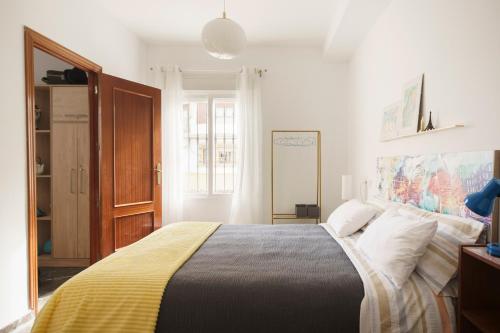 1 dormitorio con 1 cama grande con manta amarilla en Apartamento turístico Travelers, en Baena