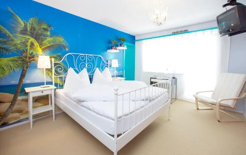 a bedroom with a white bed with a palm tree mural at Arena Lodge in Flims