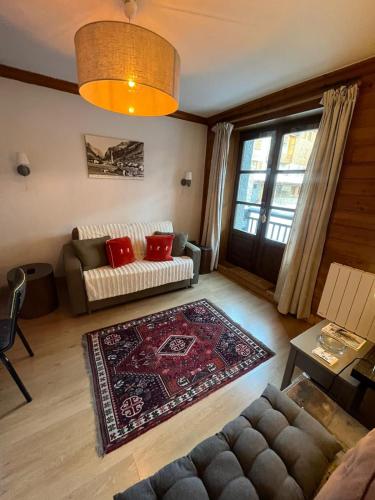 un salon avec un canapé et un tapis dans l'établissement Adorable 30m2 Coeur de Val 1 chambre 2 lits, à Val dʼIsère