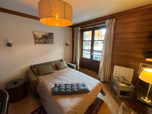 um quarto com uma cama e uma grande janela em Adorable 30m2 Coeur de Val 1 chambre 2 lits em Val dʼIsère