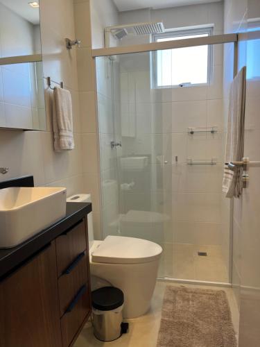 uma casa de banho com um WC e uma cabina de duche em vidro. em Residencial Atalaia - Praia do Gravatá - Beto Carrero World em Navegantes