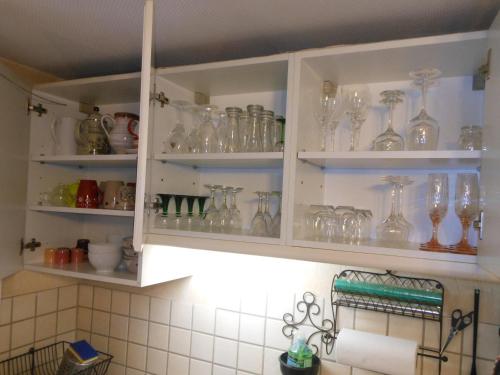 a kitchen cabinet filled with lots of glass vases at Gite Le Petit Moulin in Rosenwiller