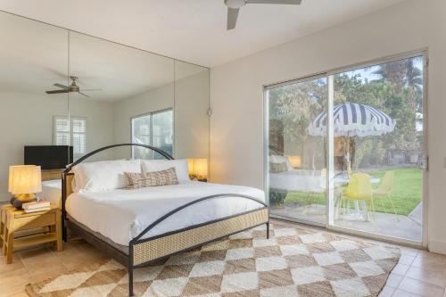 1 dormitorio con 1 cama y puerta corredera de cristal en Painted Sand by AvantStayLuxe Design in Coachella, en Bermuda Dunes
