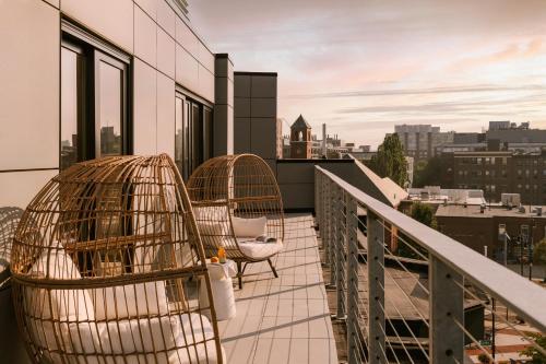 a balcony with two bird cages and chairs on a building at Sonder 907 Main in Cambridge
