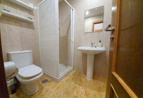 uma casa de banho com um WC, um chuveiro e um lavatório. em Cumbres de los Picos Apartamento Urriellu em Poo de Cabrales