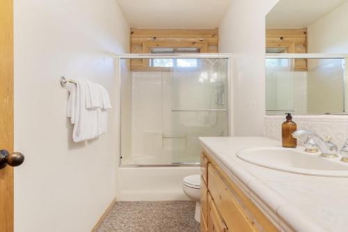 La salle de bains est pourvue d'une douche, d'un lavabo et de toilettes. dans l'établissement Tanglewood by AvantStay 10mins to Bear Mountain Contemporary Hillside Cabin, à Big Bear Lake