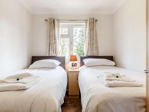 Duas camas num quarto com uma janela em 3 Bed in Dartmoor National Park 06199 em Okehampton