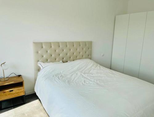1 dormitorio con cama blanca y mesita de noche en One bedroom in center with Terrace and Parking, en Luxemburgo