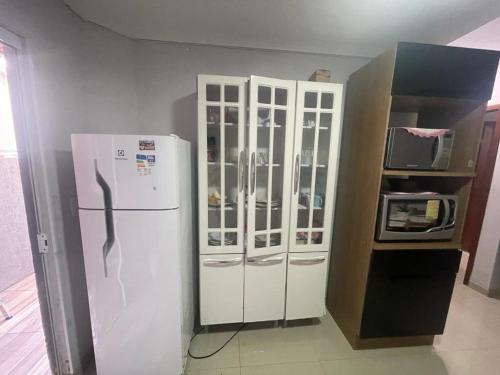 uma cozinha com um frigorífico branco e um micro-ondas em APARTAMENTO FIRMINO SAGAZ em Florianópolis
