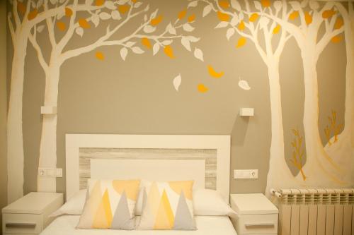 ein Schlafzimmer mit an der Wand gemalten Bäumen in der Unterkunft Cumbres de los Picos Apartamento Los Abedules in Poo de Cabrales