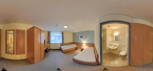 Habitación con baño con lavabo y bañera. en Hotel Restaurant Zum Jägerheim, en Brunswick
