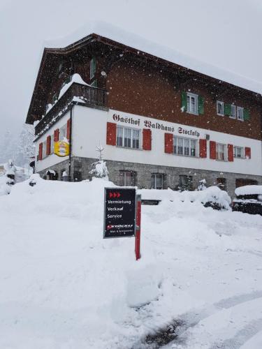 a sign in the snow in front of a building at Gasthaus Waldhaus in Melchtal