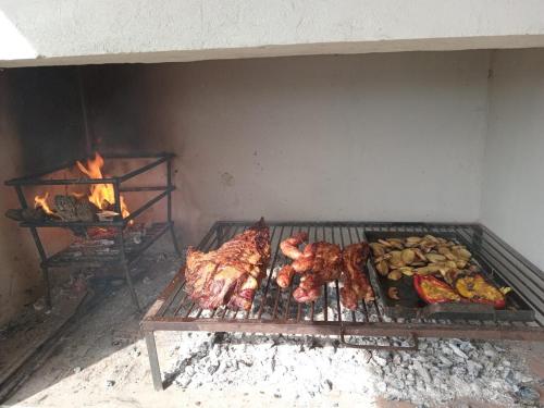 uma grelha com carne e outros alimentos em Quintas La escondida em Chivilcoy