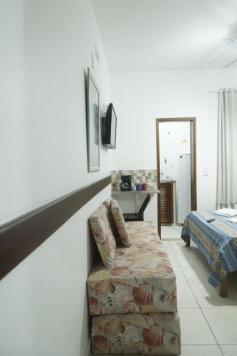 ein Wohnzimmer mit einem Sofa und einem Bett in der Unterkunft CANTO DA ARVORE 1 in Arraial do Cabo