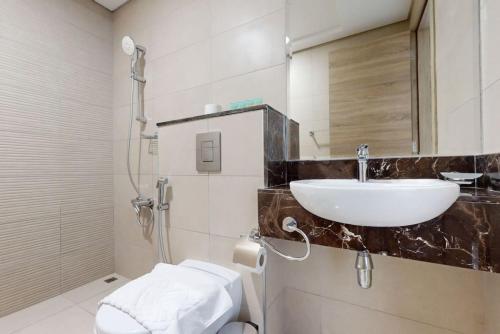 a bathroom with a sink and a toilet at Janayen Avenue - Locations in Dubai