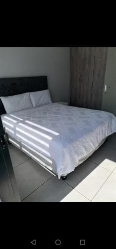 1 cama blanca grande en una habitación con en Alakhe en Randfontein