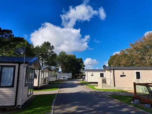 a row of mobile homes on a street at A short walk to Par Beach & coastal paths, On-site facilities. Pets welcome in Par