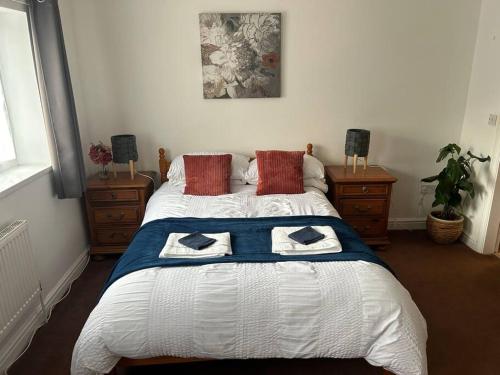 a bedroom with a large bed with two pillows at Airport Retreat in Handforth