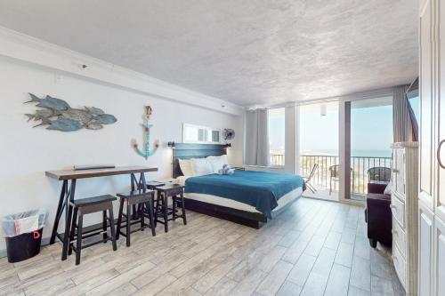 1 dormitorio con 1 cama y 1 mesa con sillas en Harbour Beach Resort 618, en Daytona Beach