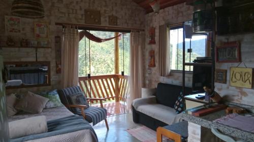 a living room with a couch and a window at Sonho na Serra Chalé 1 in Gonçalves