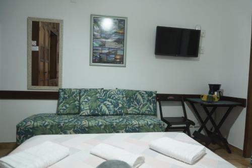 a room with a chair and a table with a television at CANTO DA ARVORE 1 in Arraial do Cabo