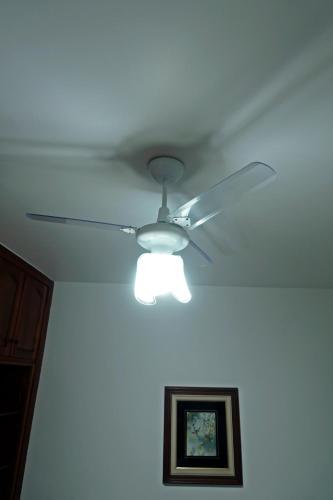 a ceiling fan with a light in a room at CANTO DA ARVORE 1 in Arraial do Cabo