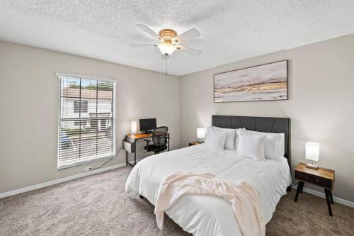 1 dormitorio con 1 cama, ventilador de techo y escritorio en Cozy Townhouse - Gym Pool Golf Fast WiFi 2B2B, en Tampa